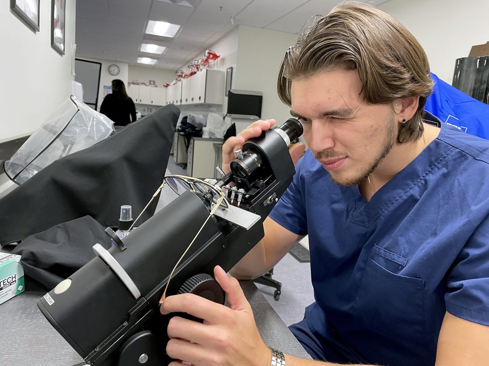 Vladislav Kirilov looking into microscope to fit a pair of glasses