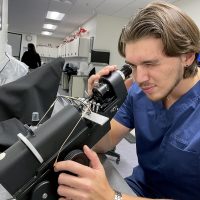 Vladislav Kirilov looking into microscope to fit a pair of glasses