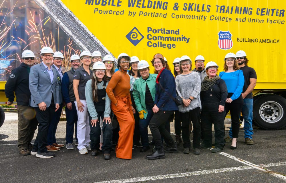 Group photo in front of mobile welding center.