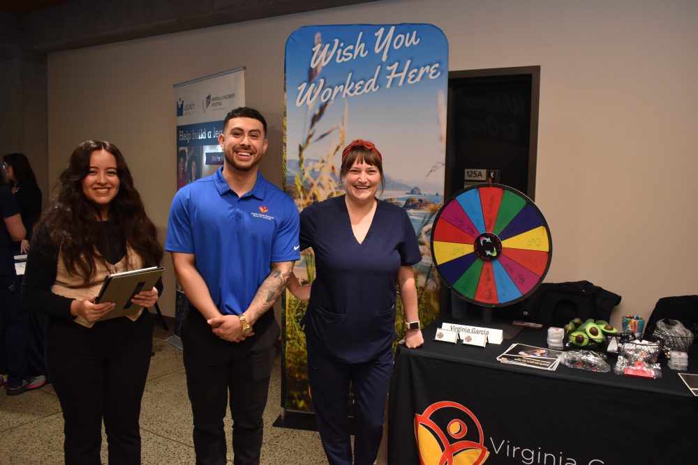Three people gather at RN exhibit.