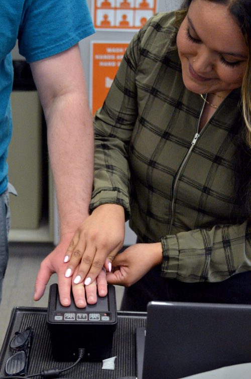 Martiza Ceja performs fingerprinting for expungement services.