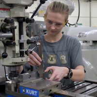 Kennedy Godfrey working a CNC in Sylvania machining shop.