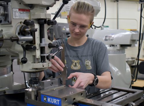 Kennedy Godfrey working a CNC in Sylvania machining shop.