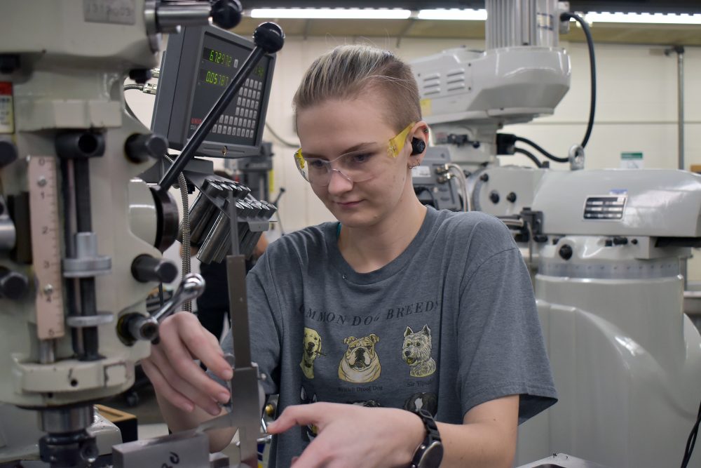 Kennedy Godfrey working a CNC in Sylvania machining shop.
