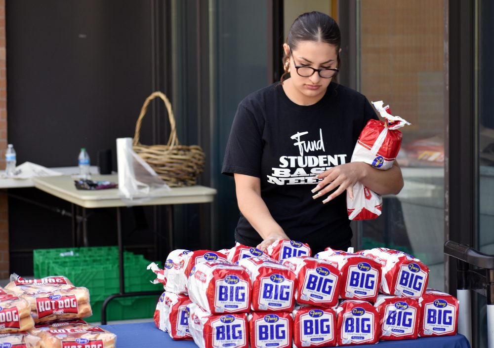 Student stocking loaves of bread
