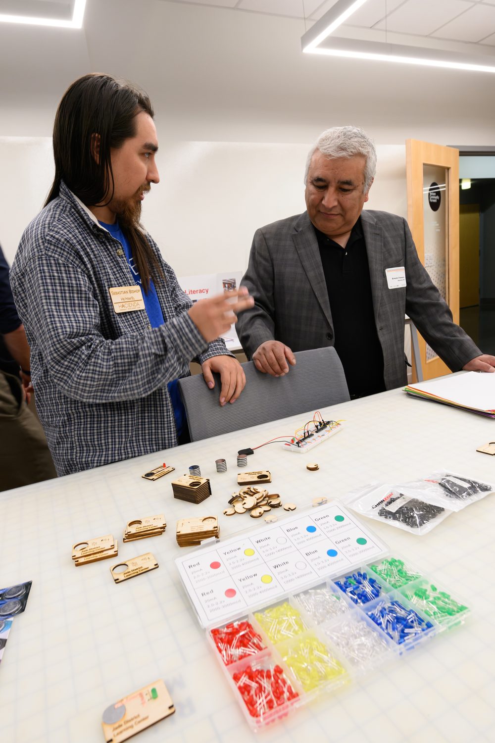 Sebastian Bishop (program coordinator with Hacienda CDC) shows Ernesto Fonseca (Hacienda CEO) items made in the learning center.