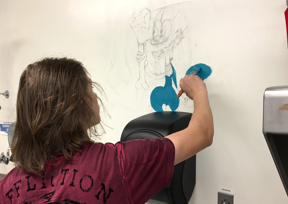 Student paitning mural outline