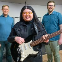 Music instructors Jason Palmer (left) and Samuel Barbara with Sofia Nava Ulacio.