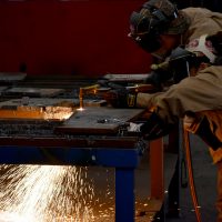 Instructor Todd Barnett assists Two Crow in a welding technique.