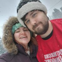 Black line drawing tattoo of a rat scientist on a woman's arm.