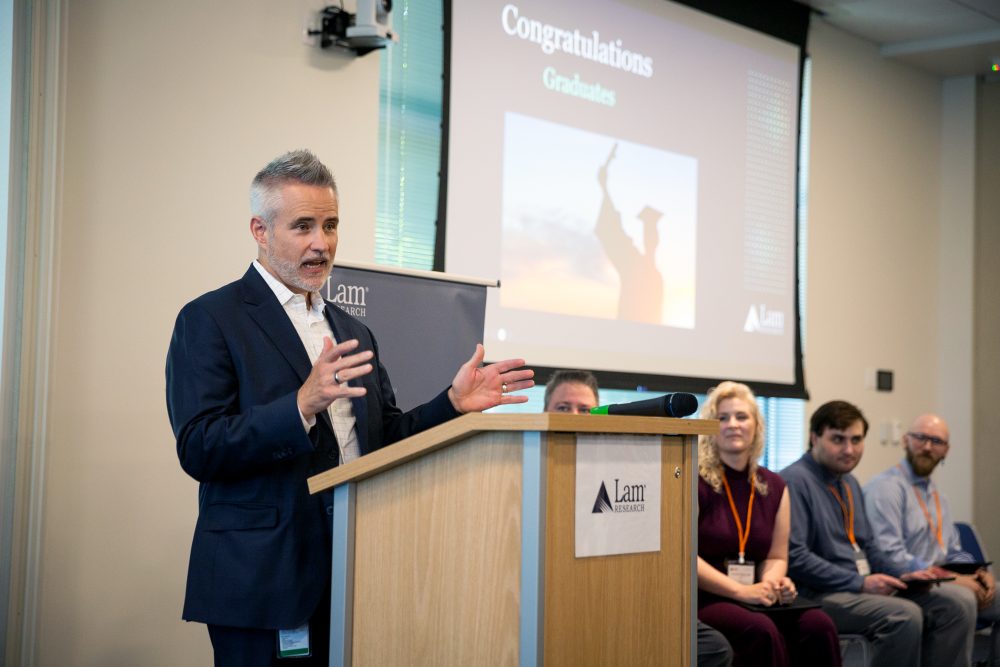 Lam Research Corporate VP and GM Aaron Fellis addresses the graduating class of the company's first-ever Microscopy Technician Training Program, remarking on the importance of workforce development for in-demand roles within the fast-growing semiconductor industry.
