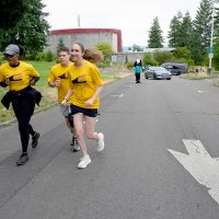 Clackamas President Tim Cook (right) sprints up hill near Sylvania's Performing Arts Center with PCC President Adrien Bennings (baseball cap).