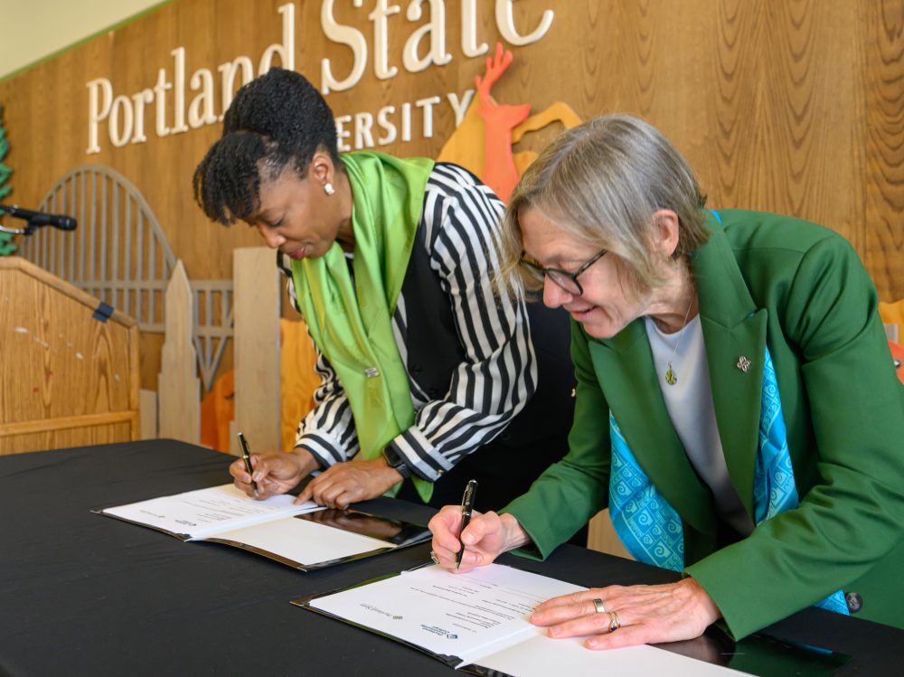 Adrien Bennings and Ann Cudd sign the MOU