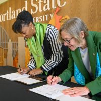 Adrien Bennings and Ann Cudd sign the MOU