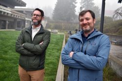 Adam Holzschuh and Eric Brurud in front of HT courtyard, arms folded.