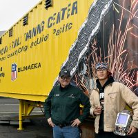 Welding faculty Todd Barnett with student Ruben Gonzalez in front of Mobile Welding Trailer.