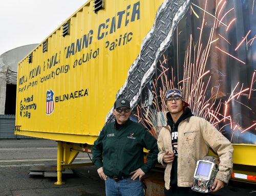 Welding faculty Todd Barnett with student Ruben Gonzalez in front of Mobile Welding Trailer.