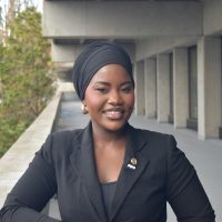 Woman in headwrap smiles.