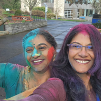 Two women taking a selfie covered in holi colors.