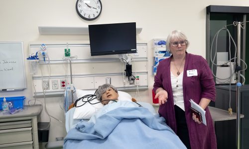 Program Dean for Health & Emergency Professions Lisa Regan-Vienop demonstrates a nursing manikin.