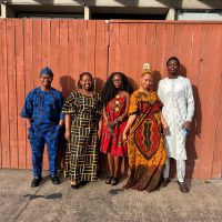 African Students of PCC wear vibrant textiles and clothing from their homeland including head scarves, dresses and one white suit.