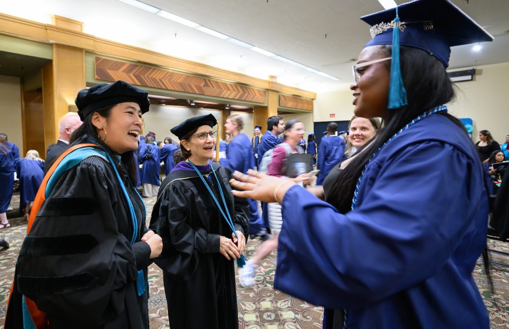 Katy Ho and Suzanne Bonamici greeting a graduate.