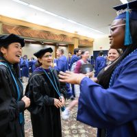 Katy Ho and Suzanne Bonamici greeting a graduate.