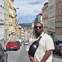 Man stands amongsr street in histroic Prague.