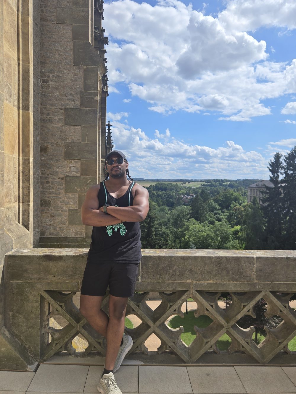 Black young man stands between historic buildings in Europe.