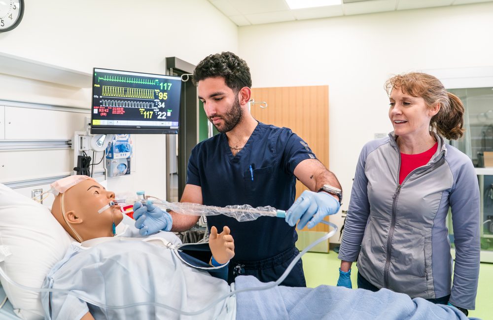Nursing student and patient robot with instructor.