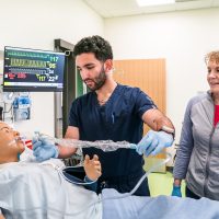 Nursing student and patient robot with instructor.