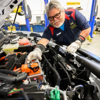 Rick Cruz working on a new EV vehicle in the Sylvania Automotive Shop.