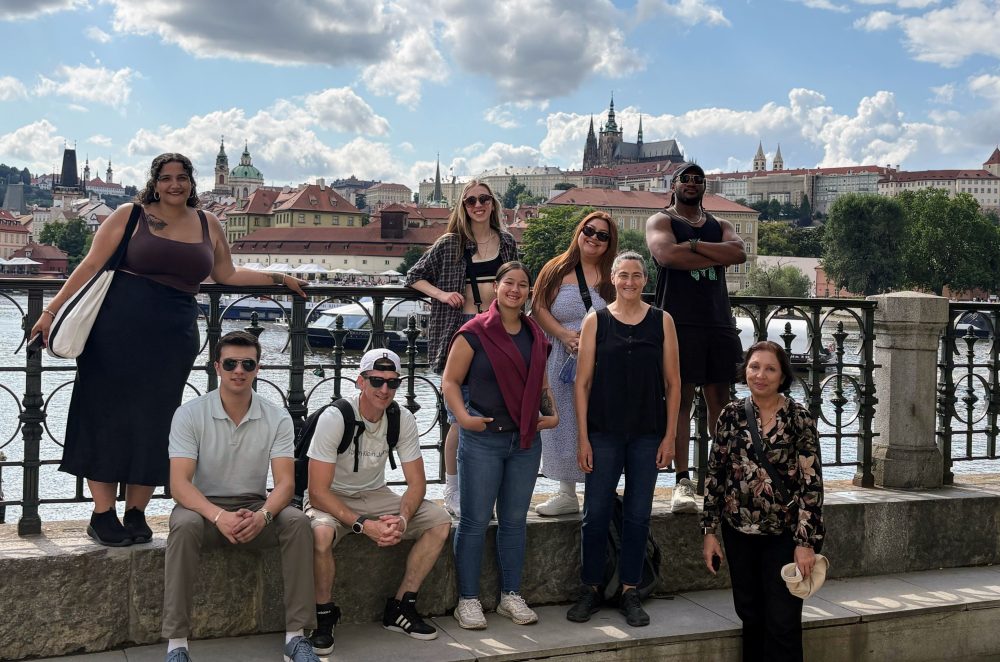 A hoarde of students gather near the river bank for a group photo.