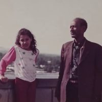Small girl and grandfather appear in vintage photo.