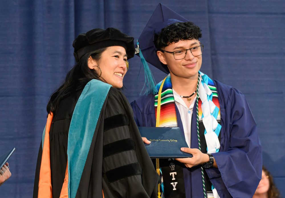 PCC Interim president Dr. Katy Ho on stage with student.
