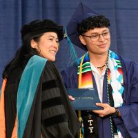 PCC Interim president Dr. Katy Ho on stage with student.