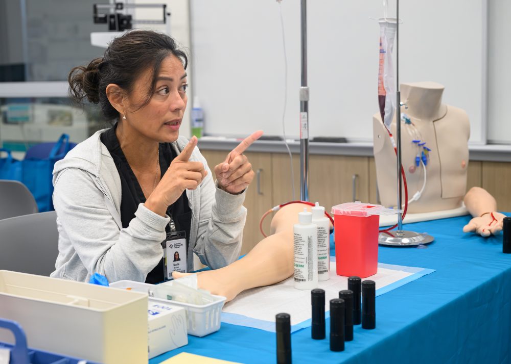 Healthcare instructor advises on blood taking.