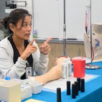 Healthcare instructor advises on blood taking.