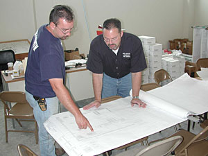 Mike and his brother look at plans.