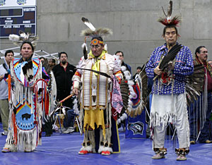 Dancers at the powwow round the gym.