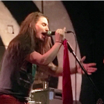 Metal vocalist Gene Summers sings into a microhone.