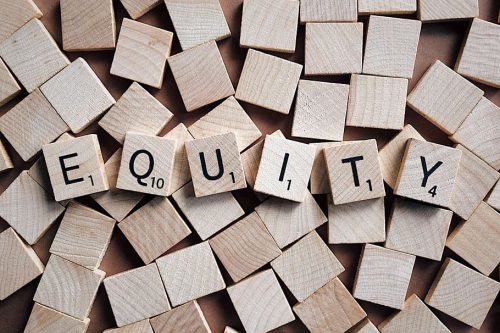 scrabble tiles spell the word "equity"