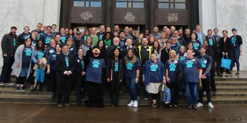 Group of faculty and staff standing in front of a building