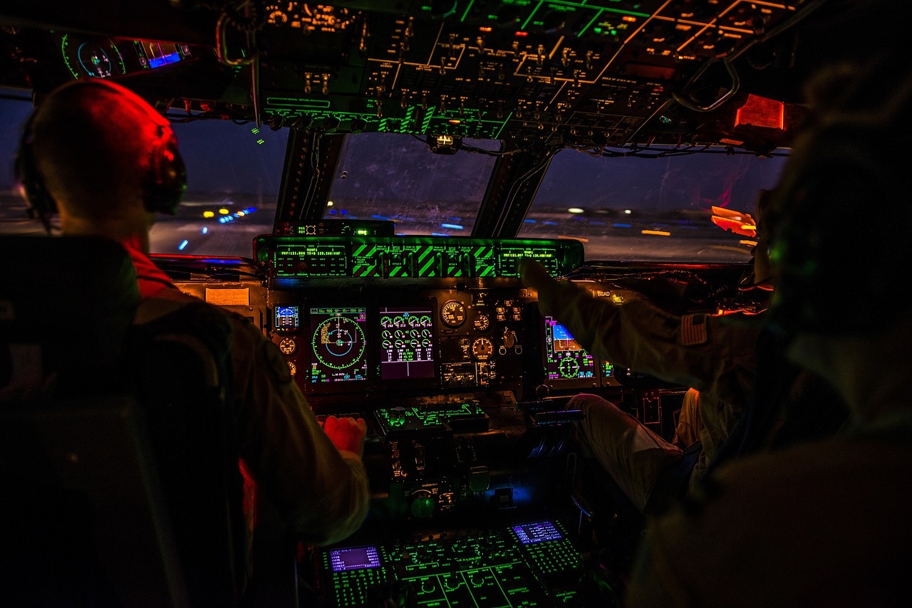 View from the cockpit of a plane at night. The instrumentation is all lit up.