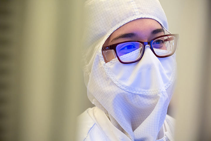 View of a woman's face wearing a protective uniform for a semiconductor lab. Photo credit: Intel