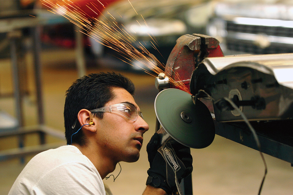 Automotive Service student working with a grinder