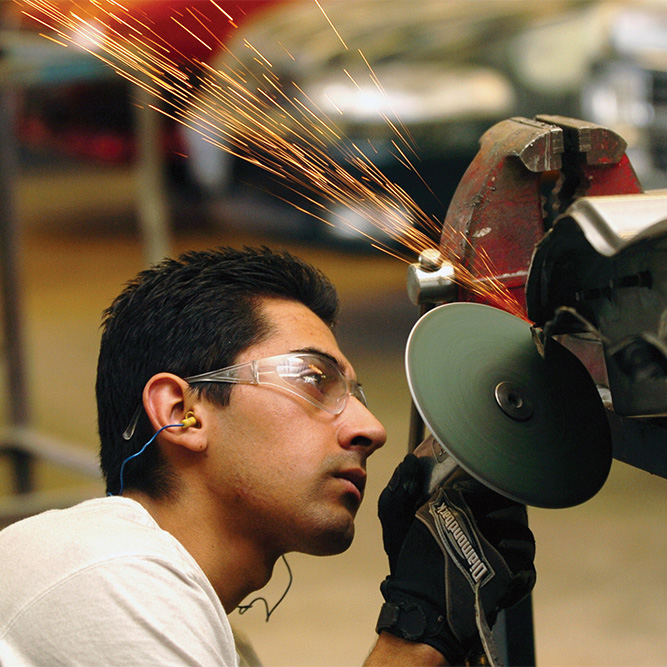 Automotive Service student working with a grinder