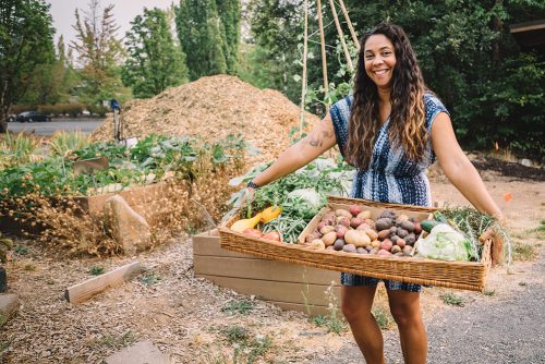 Venus Barnes holding a basket of food that she grew