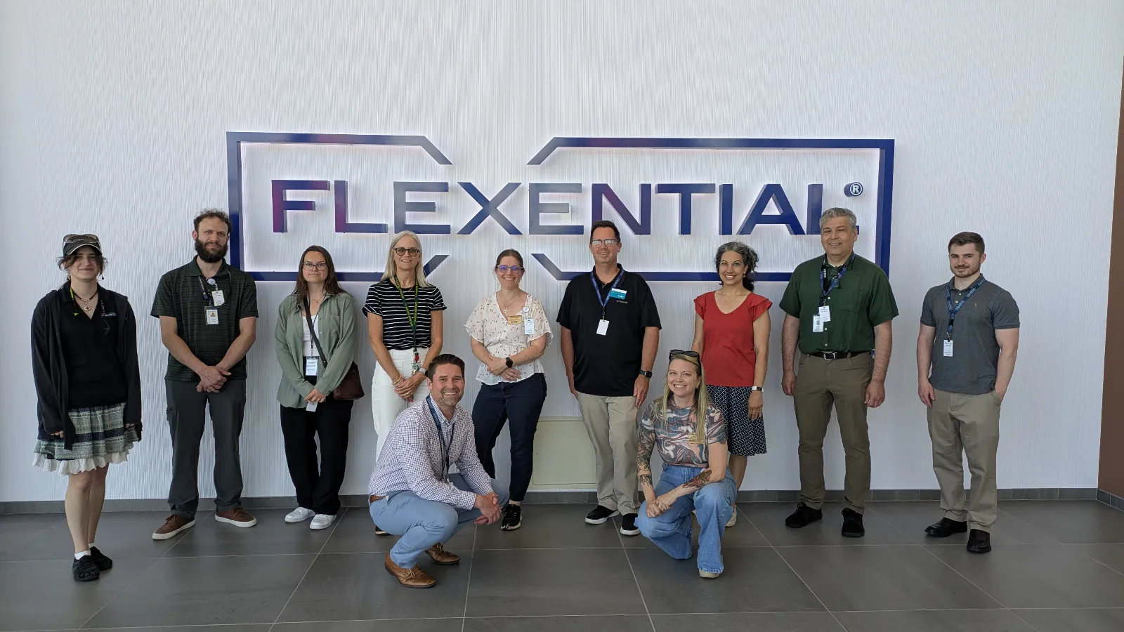 Group in front of large logo on recent tour of Flexential's Data Center in Hillsboro