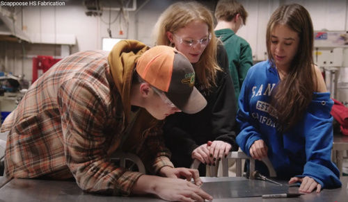 Group of three happy students working together.